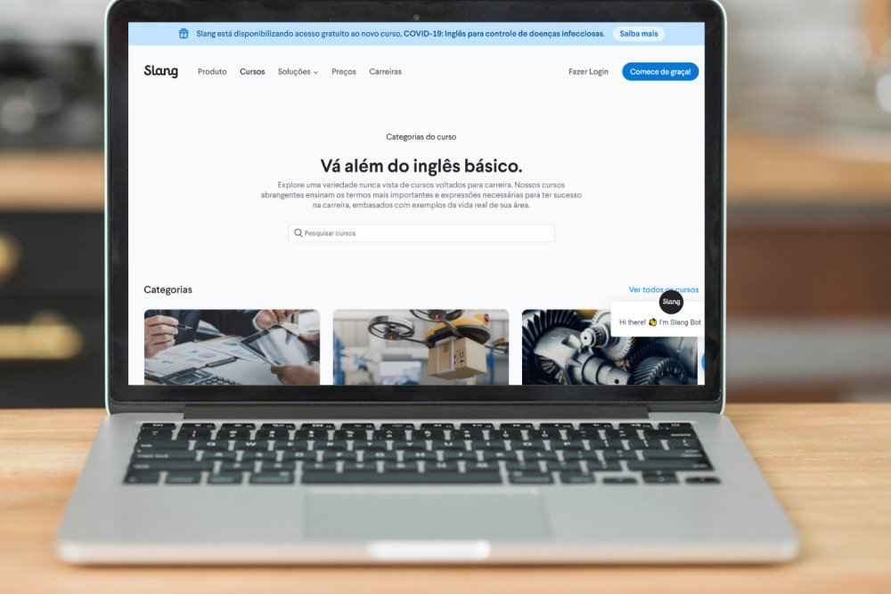 Um laptop aberto mostra a página de cursos de inglês profissional da Slang.
